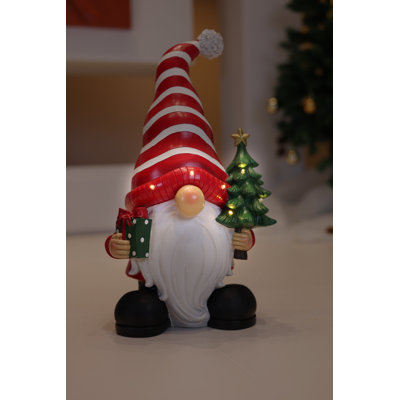 Père Noël tenant un sapin de Noël illuminé à l'intérieur et à piles