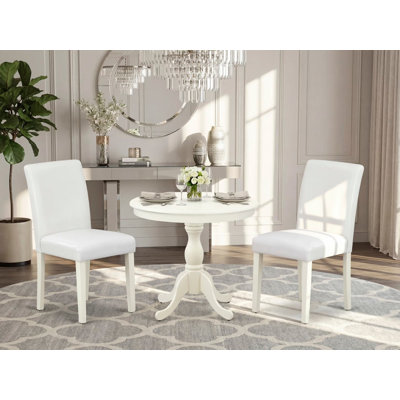 L'ensemble de meubles de salle à manger 3 pièces comprend une table de cuisine ronde avec piédestal et 2 chaises Parsons en similicuir blanc, lin blanc