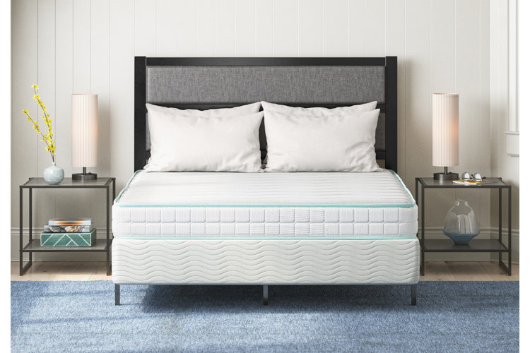 mattress on a metal bed with two metal nightstands