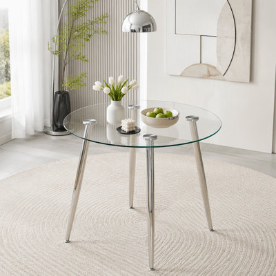 Table de salle à manger ronde avec dessus en verre et pieds argentés