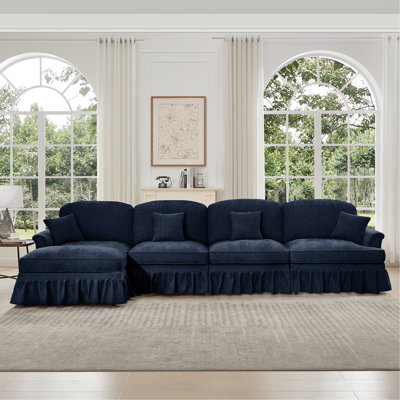 Canapé modulaire classique à trois places en forme de L avec accoudoirs évasés et volants amovibles, jupes plissées et pieds fuselés, canapé en chenille confortable à quatre places avec repose-pieds mobile, bleu