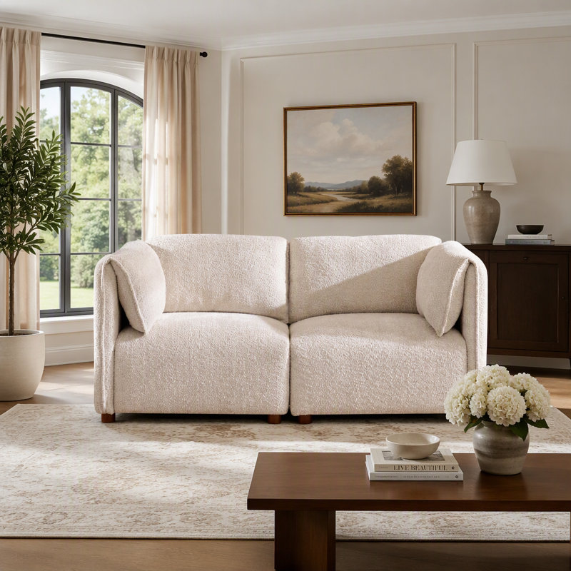 Canapé d'angle modulaire en tissu bouclé, avec configuration flexible et coussins profonds, idéal pour les espaces de vie modernes.