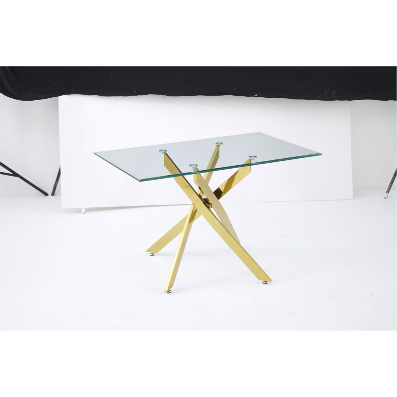Le plateau de table rectangulaire moderne en verre trempé est associé à un cadre en fer doré, mesurant 47,24 pouces de longueur.