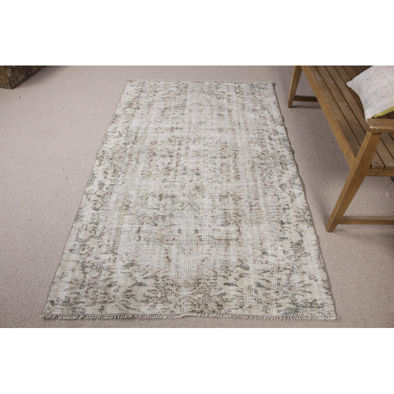 Faites l'expérience de la sensation moelleuse de ce grand tapis turc en laine beige dans votre salle à manger