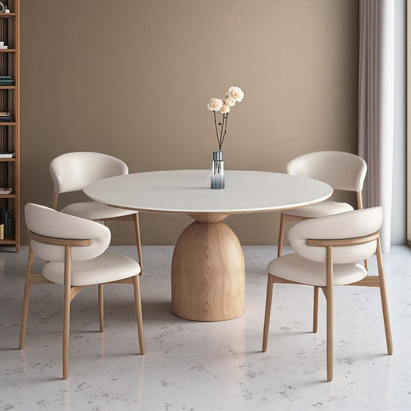 Tables rondes pour salle de pause en dalle de pierre, jumelées à quatre chaises en cuir massif.