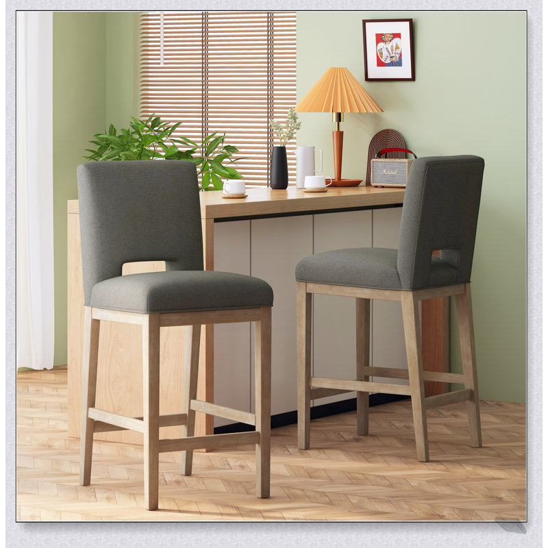 Tabourets de bar modernes et rembourrés avec des pieds en bois robustes, parfaits pour les cuisines et les salles à manger contemporaines.