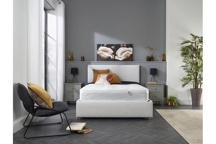 large white mattress in a modern bedroom with a gray floor, wall, and side tables