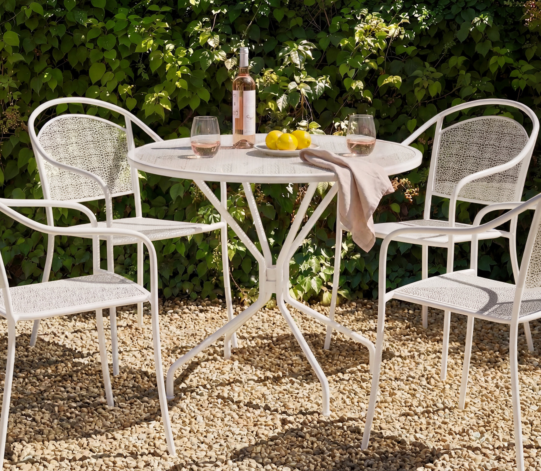 Table blanche, chaises, vin et citrons.