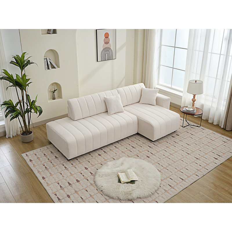Canapé d'angle capitonné en L d'inspiration scandinave avec coussins décoratifs