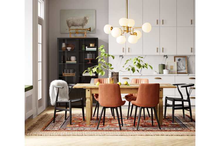 sputnik chandelier above a rustic wood dining table and mismatched dining chairs