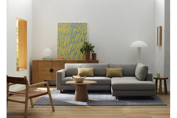 Modern living room tip on how to decorate your first apartment with a modern gray sofa, modern style wall art, lighting and decor