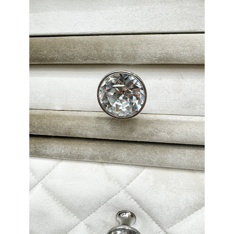 Table de chevet beige en velours avec trois tiroirs et une surface pour une ambiance de chambre à coucher confortable