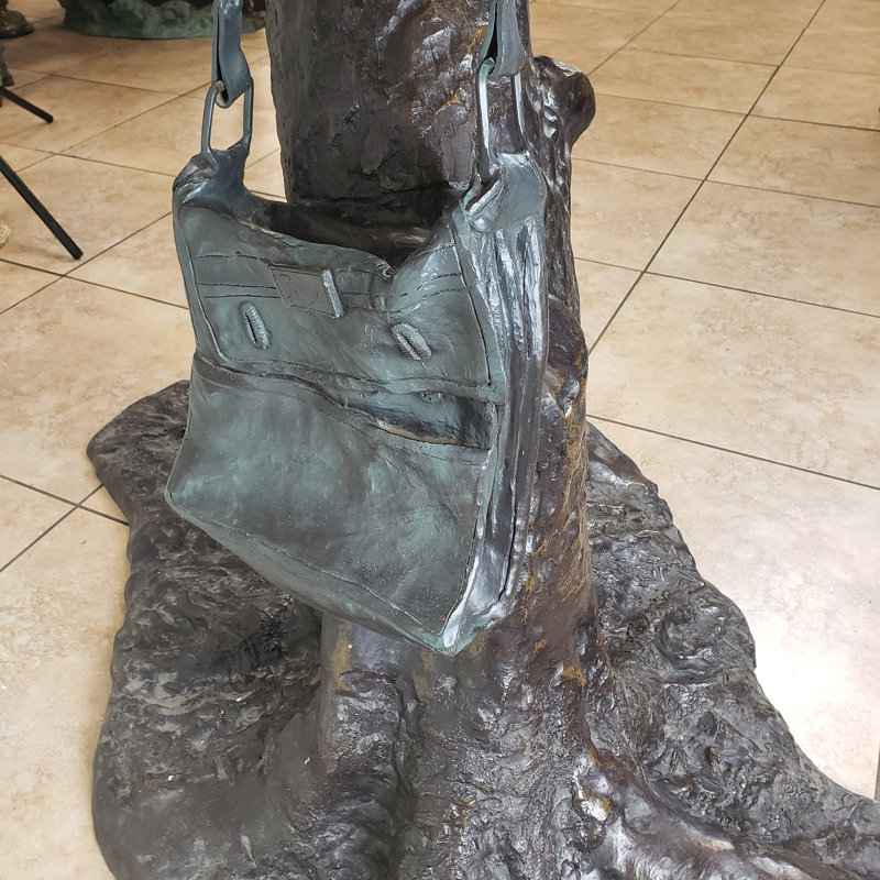 Statue bronze d'un garçon sur un arbre