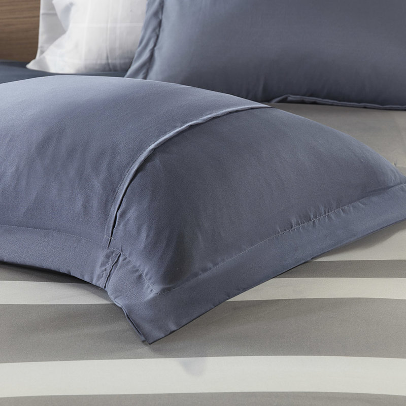 Literie simple avec édredon rayé et draps - Coussin bleu et gris