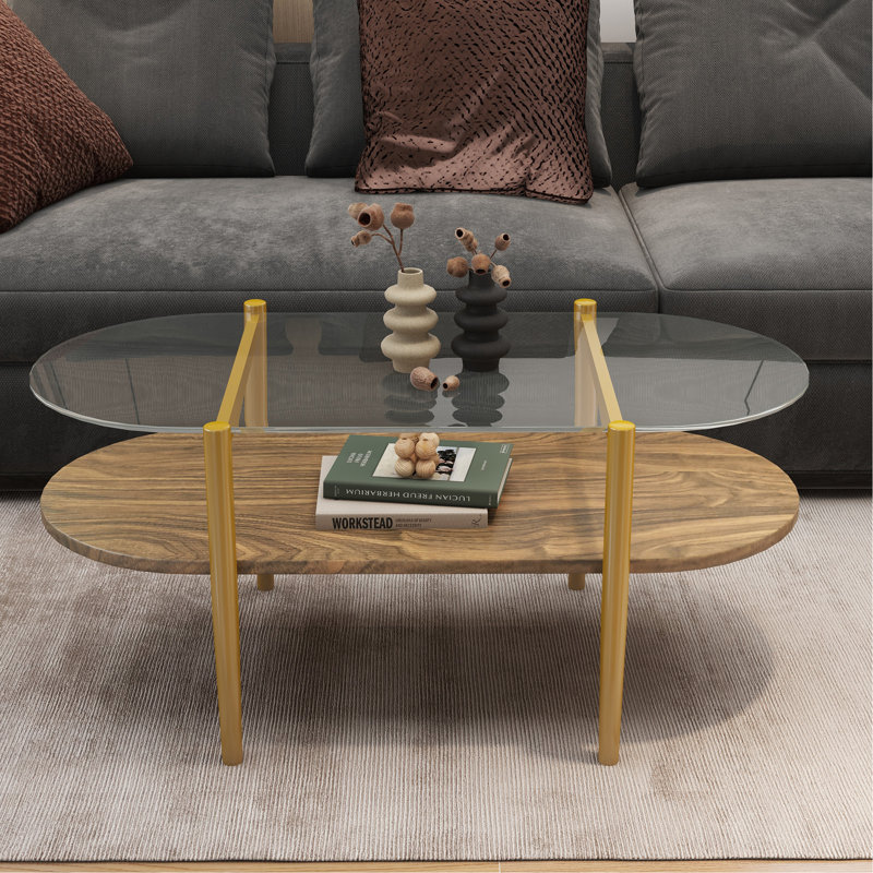 Table basse ovale en verre, de conception moderne Mid-Century, L 41 x l 21 x H 17 po, pour le salon, structure à 2 niveaux, plateau en verre transparent et tablette en bois au fini noyer, pieds coniques avec cadre à finition dorée