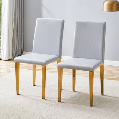 Ensemble de 2 chaises de salle à manger en polyuréthane gris clair: hauteur de 35,4 po, dossier ergonomique de 18,5 po, siège en éponge de 17 po x 16 po, parfait pour la salle à manger, le bureau personnel et l'espace de vie, élégant et confortable. Pieds en métal doré.