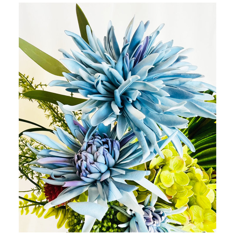 Arrangement de fleurs artificielles dans un vase en verre lesté