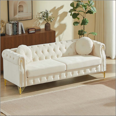 Canapé Chesterfield en velours avec deux coussins ronds, avec des clous en cuivre et des boutons capitonnés, avec des pieds en métal. La conception en boucle permet de suspendre des ornements de dessins animés.
