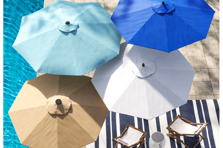 collection of the best beach umbrellas on a poolside patio above outdoor lounge chairs