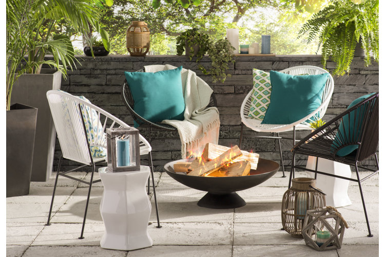 round metal fire pit in the center of four outdoor papasan chairs