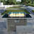 Propane Gas Fire Pit Table With Glass Wind Guard And An Open Basket-wave Patterned Wicker-947424578