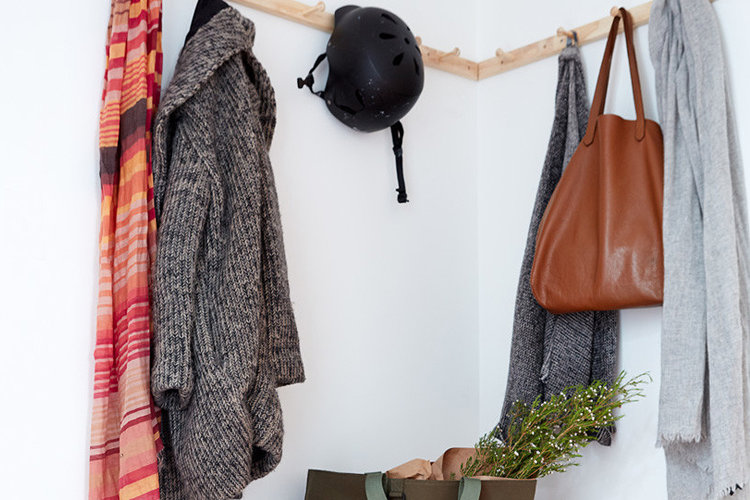 An entryway with a wall mounted coat rack.