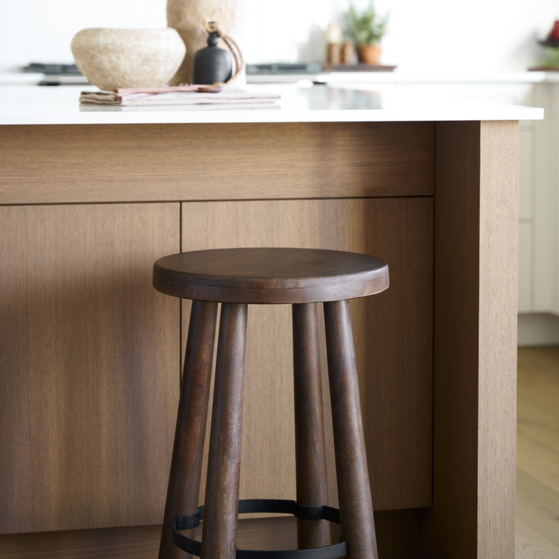 Tabouret en bois massif Oxley avec finition brun foncé et repose-pieds en métal noir mat