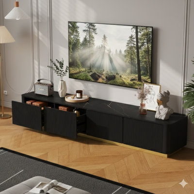 Meuble télé de luxe à cannelures noires avec plateau en faux marbre et quatre tiroirs, conçu pour les téléviseurs de 85 po ou moins. Un centre de divertissement moderne avec un profil incurvé et une base dorée pour le salon.