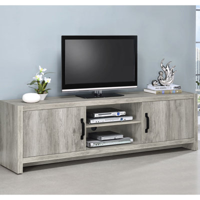Meuble télé de 71 pouces en bois flotté gris conifère, offrant un rangement polyvalent et un ajout élégant au salon. Console en bois flotté, dotée d'un compartiment central ouvert dissimulant des compartiments.