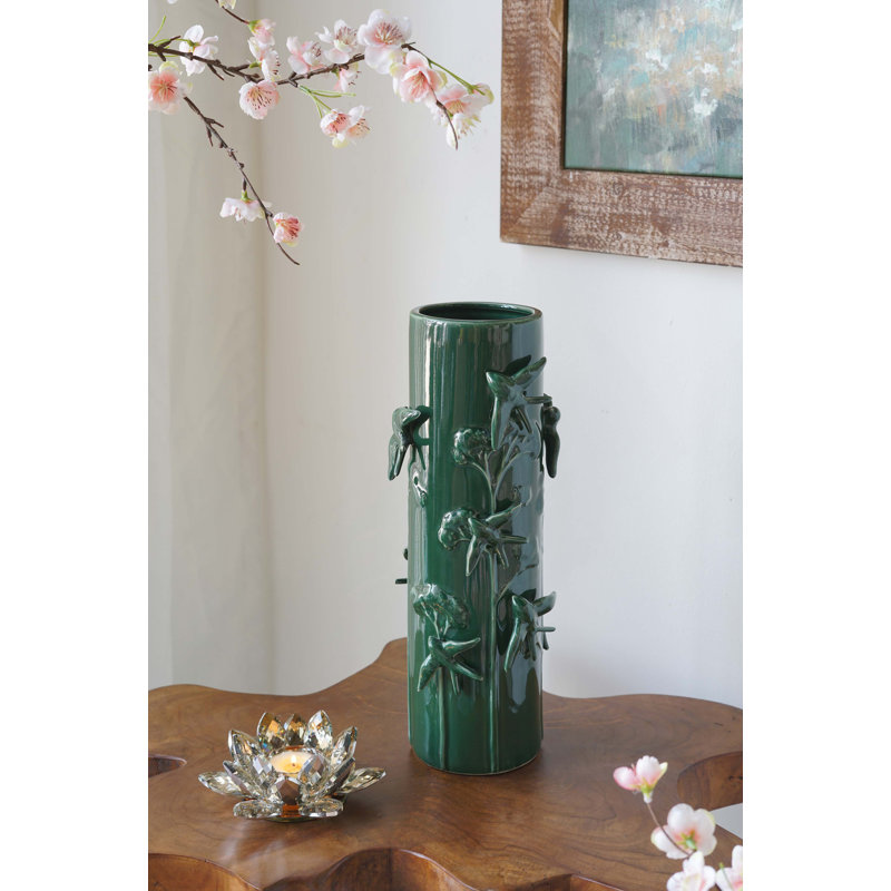Grand vase en céramique verte orné d'oiseaux et de vignes sculptés.