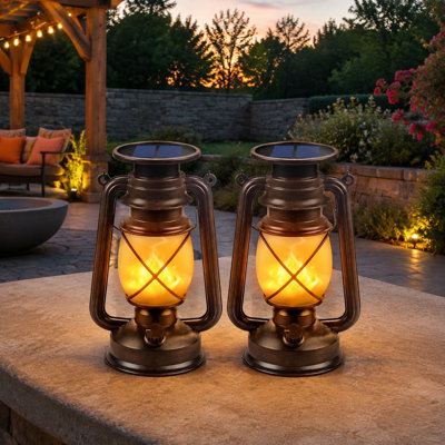 Vintage-style waterproof hanging solar lanterns in a 2 Pack use flickering LED light for decorative outdoor placement on patios, in gardens, porches, yards, pathways, campsites, tables, holidays, or Halloween displays.
