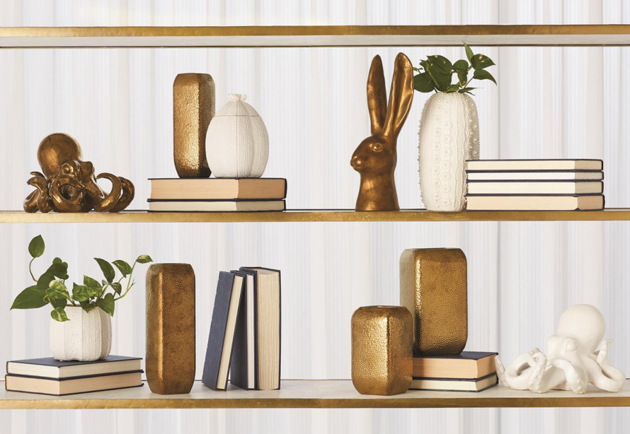 Decor on a gold shelf including vases, books, and octopus sculptures.