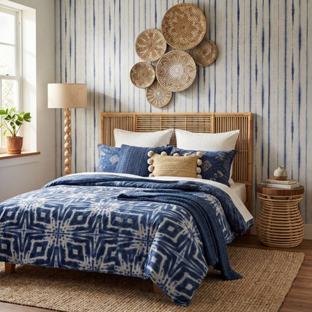 Bedroom featuring a rattan bed, indigo bedding, and woven basket decor.