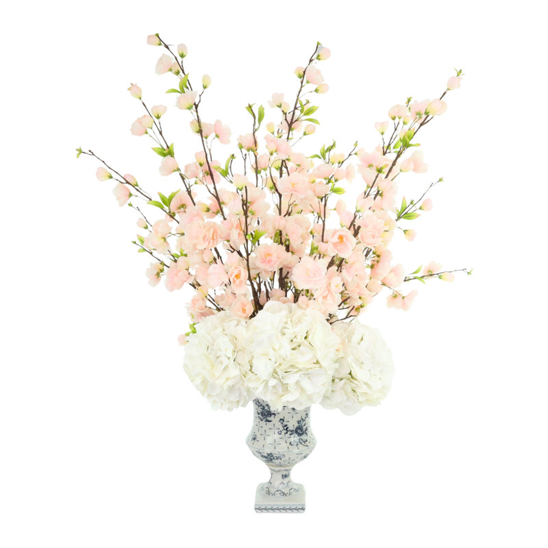 Arrangement de fleurs de cerisier et d'hortensias dans un vase en céramique