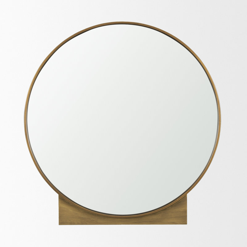 Feltner est un miroir rond avec un cadre en métal doré brossé.
