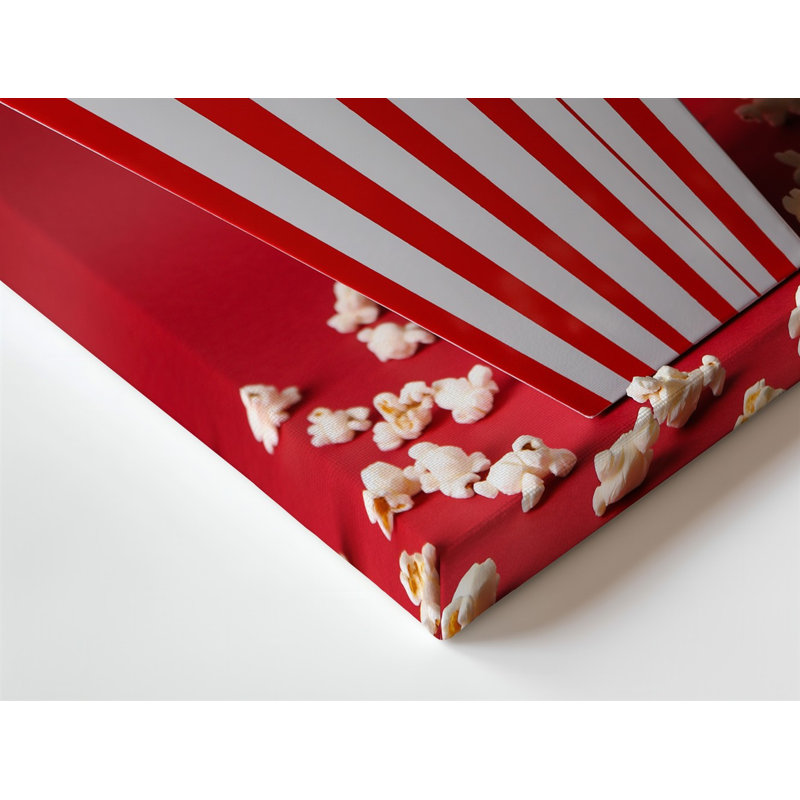 La toile crée une image en gros plan éclatante d'une boîte à popcorn rayée classique avec un popcorn blanc moelleux posé sur une toile