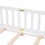 Lit plateforme au sol avec garde-corps et porte, offrant un repos confortable et un assemblage facile pour une chambre à coucher relaxante.