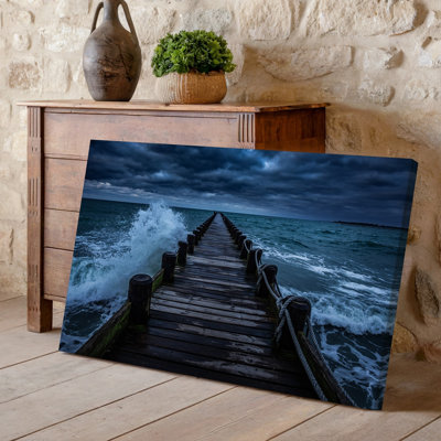 Canvas A Weathered Wooden Pier Extends Into A Tumultuous Sea Surrounded Wall Art By Dark Ominous Storm Clouds That Dominate The Sky Canvas Wall Art