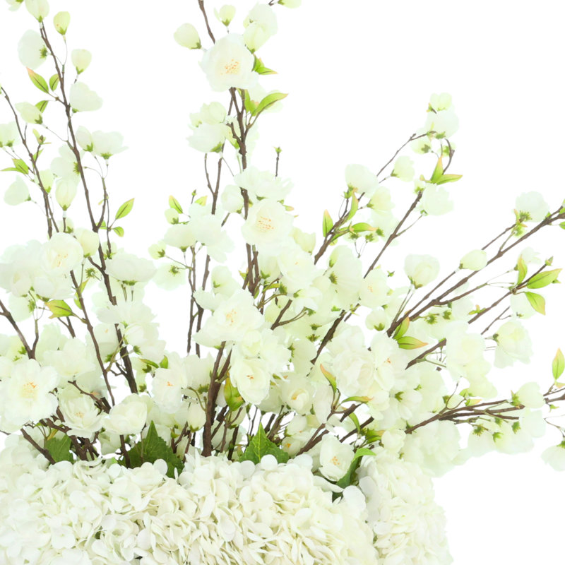 Arrangement de fleurs de cerisier et d'hortensias dans un vase en céramique