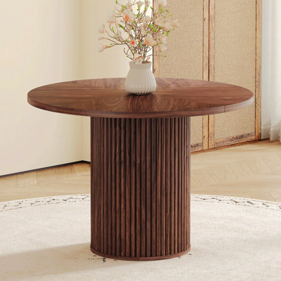 Une table de salle à manger circulaire moderne avec un diamètre de 42 po, avec deux textures de noyer en forme d'éventail en diagonale, interprétant l'esthétique et la fonctionnalité de la maison.