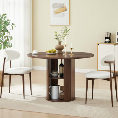 Table de salle à manger ronde avec deux chaises rembourrées et une tablette de rangement ouverte à deux niveaux intégrée pour des espaces compacts et une réception sans effort.