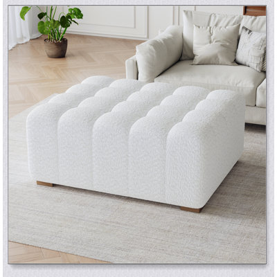 Repose-pieds polyvalent Boucle avec un tissu blanc doux et un design polyvalent, parfait pour les salons et les chambres à coucher.