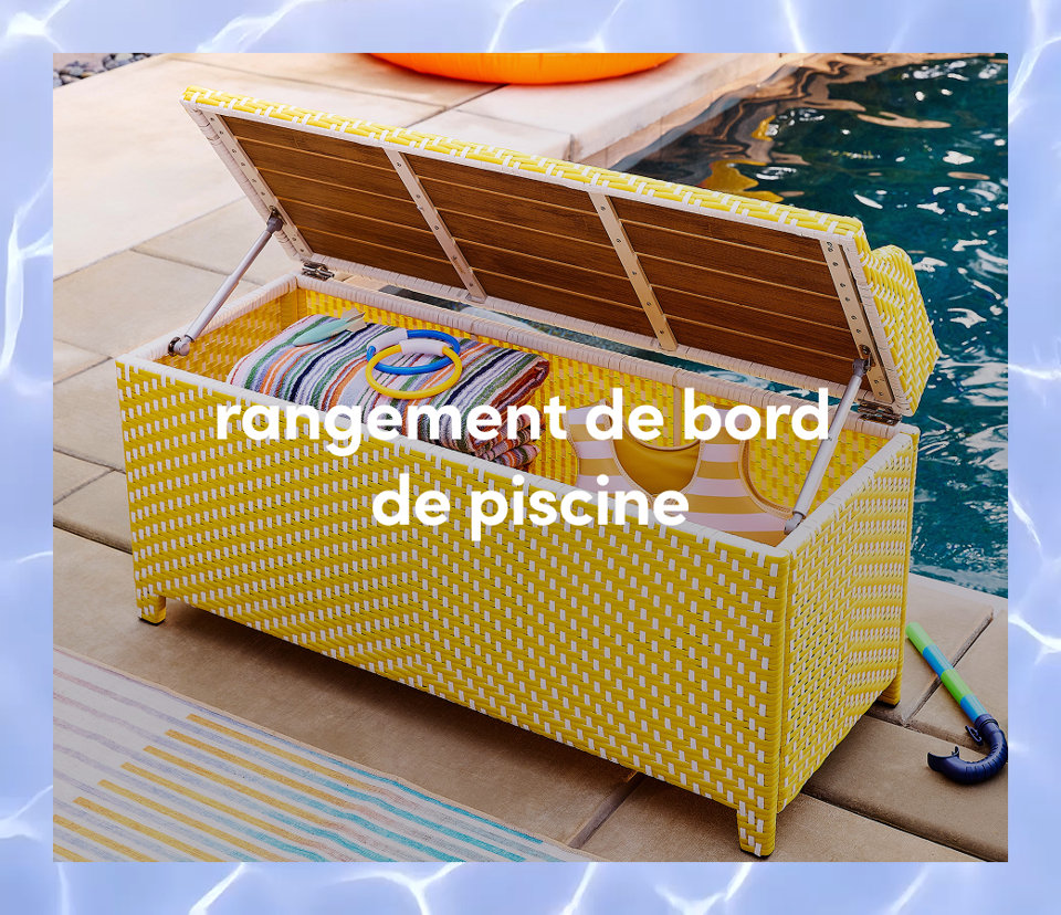 Un banc de rangement d extérieur tressé jaune et blanc avec le couvercle ouvert, rempli de serviettes de piscine et d anneaux colorés.
