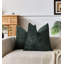 Set of two square dark green textured chenille throw pillows on a beige sofa