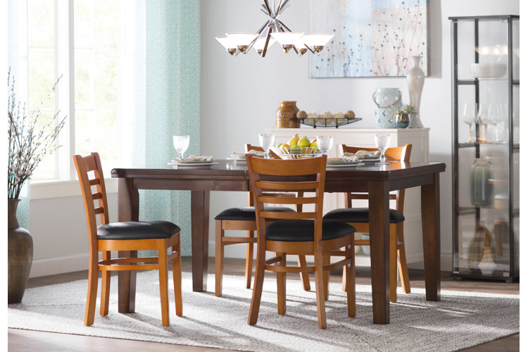 medium wood ladder back chairs with black cushions around a brown rectangular dining table in a transitional dining room