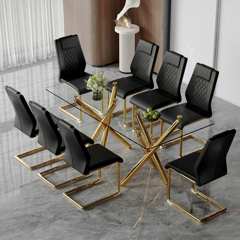 Ensemble de table et de chaises. Ensemble de table de salle à manger moderne et luxueux en verre trempé transparent avec 8 chaises. Pieds de table en métal doré à double fourche.