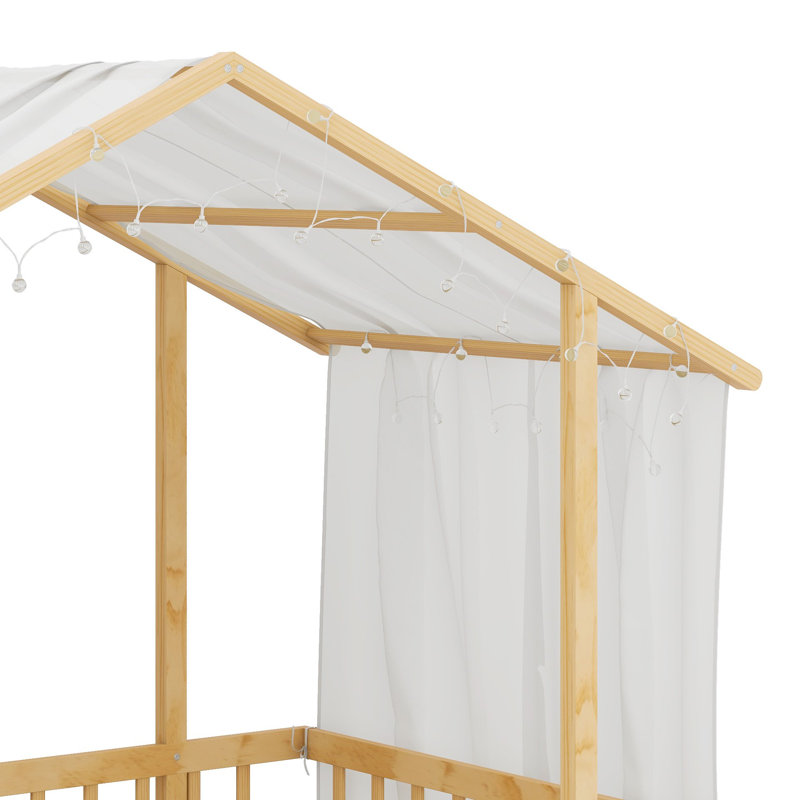 Un lit plateforme avec une structure en forme de maison, un ciel de lit transparent et des lumières scintillantes crée un refuge douillet pour les enfants.