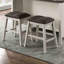 5 comptoirs de style transitionnel, tabourets gris foncé, table, pieds inclinés, tablettes de rangement ouvertes