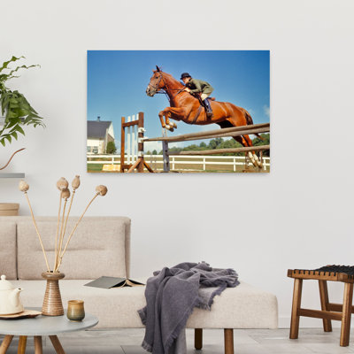 Femme des années 1970, équestre à cheval sautant en prenant un cheval brun au-dessus d'un saut d'obstacle, cheval contemporain, art mural