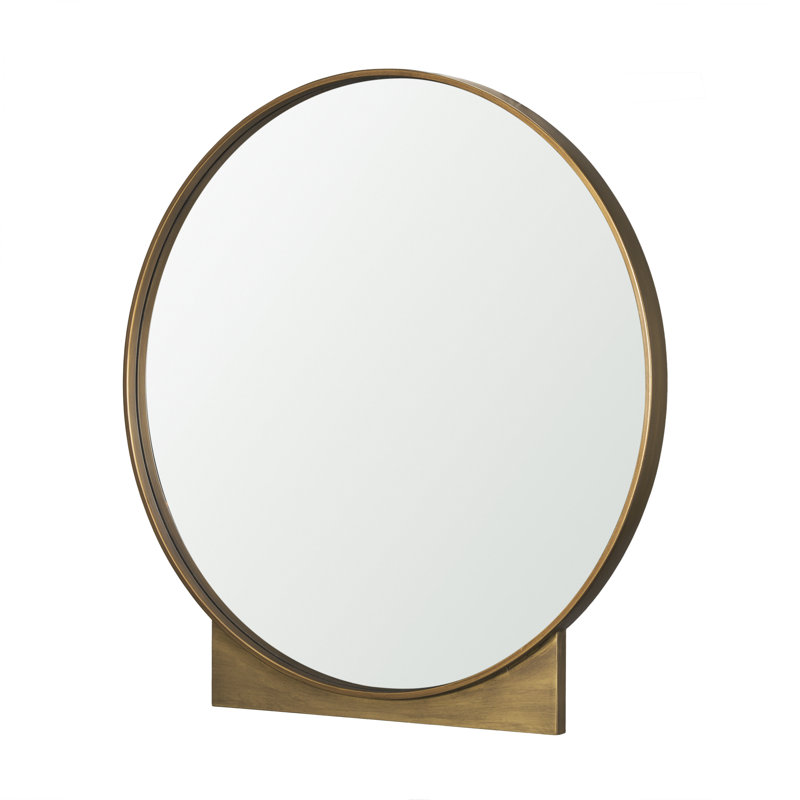 Feltner est un miroir rond avec un cadre en métal doré brossé.